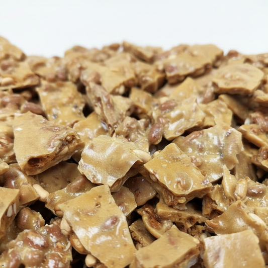 Close-up of a pile of peanut brittle on a white background